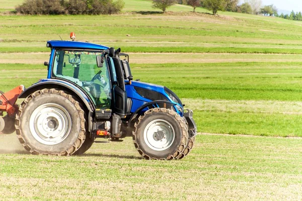 Синій трактор на полі. Працюючи на сільськогосподарській фермі в Чехії. Весняні роботи в сільському господарстві. — стокове фото