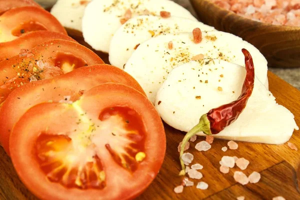 Frischer Mozzarella-Käse und Tomaten auf dem Schneidebrett. gesunde Ernährung. Chilischoten mit Käse. — Stockfoto