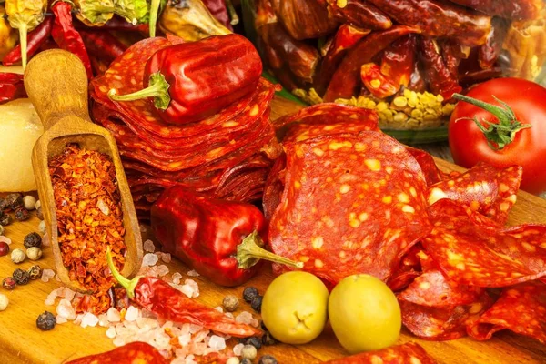 Salchicha o salami con chile con hierbas en la mesa de madera. Salami picante con chile. Alimento graso poco saludable . — Foto de Stock