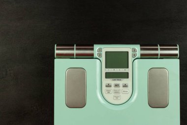 Obezite kavramı. Modern dijital ağırlık ve bacaklar. Diyette kilo kontrolü.
