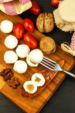 Peynir topları incir reçeli ile dolu. Tahta tahtada taze peynir. Tatlı incelik.