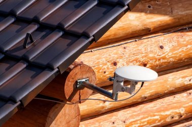 Ahşap bir evde uydu tv anteni. Tv sinyali iletimi. İnternet Erişimi. Telekomünikasyon, telekomünikasyon anlamına gelir.