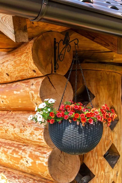 Vaso da fiori appeso su baita in legno. vaso di fiori decorativi sul cottage . — Foto Stock