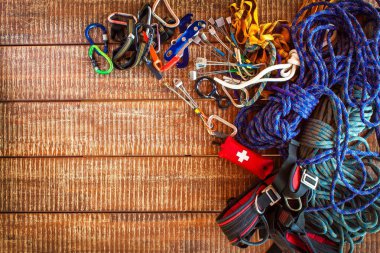 Güvenli tırmanış sporcuları için tırmanma ekipmanları. Tırmanma, speleoloji, alpinizm, kopyalama alanı ile ahşap arka plan üzerinde kullanılan güvenlik ekipmanlarından çerçeve.