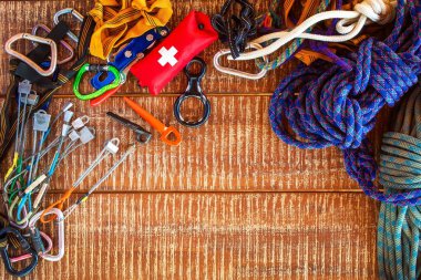 Güvenli tırmanış sporcuları için tırmanma ekipmanları. Tırmanma, speleoloji, alpinizm, kopyalama alanı ile ahşap arka plan üzerinde kullanılan güvenlik ekipmanlarından çerçeve.