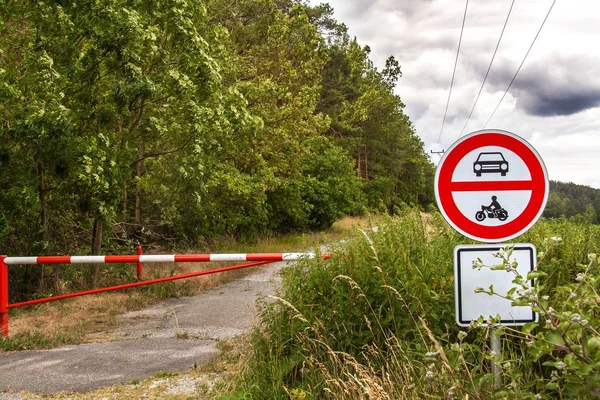 No hay entrada para vehículos de motor, solo se permite el ciclismo. Nubes de tormenta sobre el camino forestal. Entrada cerrada al bosque. Señal de tráfico . —  Fotos de Stock
