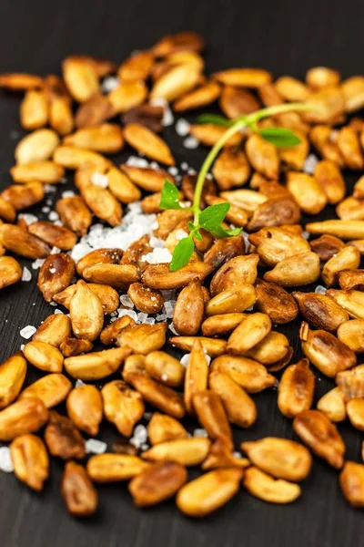 Roasted and salted sunflower seeds. Sunflower seeds in the bowl over the wooden background. Vegan food. — Stock Photo, Image