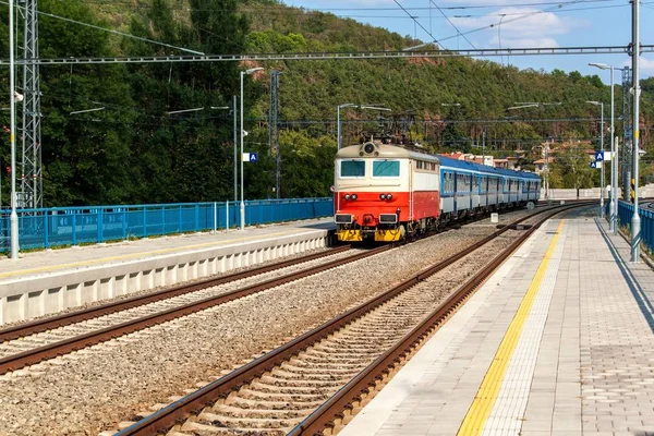 Tren en plataforma en la estación en la República Checa. Vías férreas con traviesas de hormigón. Estación ferroviaria local . — Foto de Stock