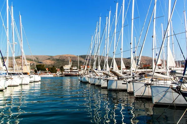 Mattina estiva nel porto. Parcheggio yacht in porto, Porto a Trogir, Croazia. Barche a vela riflesse nell'acqua. Noleggio barche . — Foto Stock