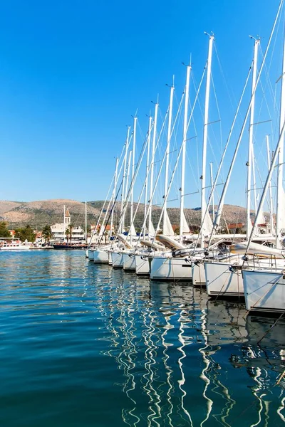 Mañana de verano en el puerto. Estacionamiento de yates en puerto, Puerto en Trogir, Croacia. Veleros reflejados en el agua. Alquiler de barcos . —  Fotos de Stock