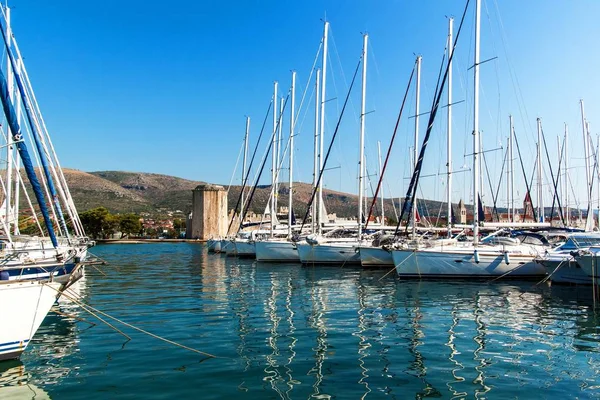 Manhã de verão no porto. Yachts estacionamento no porto, Porto em Trogir, Croácia. Veleiros refletidos na água. Aluguer de barcos . — Fotografia de Stock