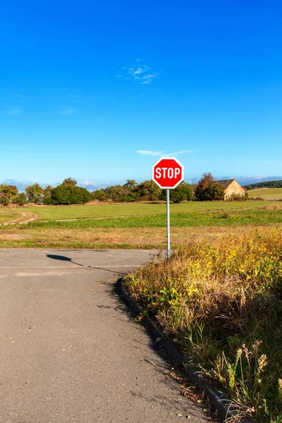 Stoppa vägskylt vid landsbygdens skärningspunkt. Transportsäkerhet. Miljö. Varningssymbol. Skyldighet att stoppa fordonet. — Stockfoto