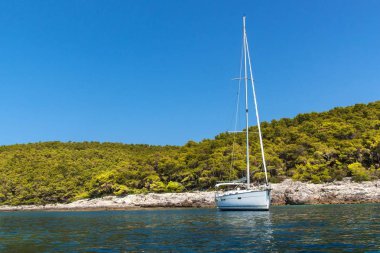 Hırvatistan sahilinde demirli bir yelkenli tekne. Yelkenliler körfezde demirledi. Yatçılık sporu. Yelkenlide tatil.