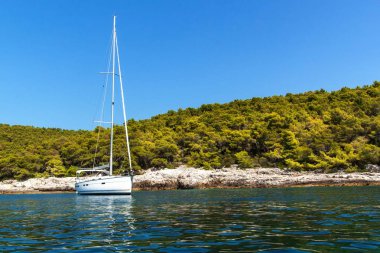 Hırvatistan sahilinde demirli bir yelkenli tekne. Yelkenliler körfezde demirledi. Yatçılık sporu. Yelkenlide tatil.