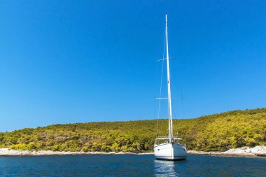 Hırvatistan sahilinde demirli bir yelkenli tekne. Yelkenliler körfezde demirledi. Yatçılık sporu. Yelkenlide tatil.