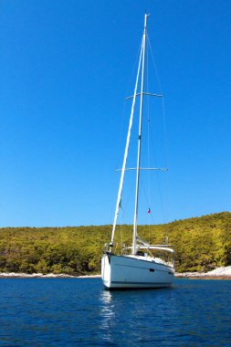 Hırvatistan sahilinde demirli bir yelkenli tekne. Yelkenliler körfezde demirledi. Yatçılık sporu. Yelkenlide tatil.