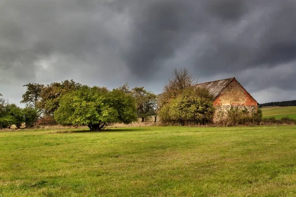 Regentag auf dem Land. Dramatischer Himmel. Bedeckter Himmel über einer alten Scheune. Weiden in der Tschechischen Republik. — Stockfoto