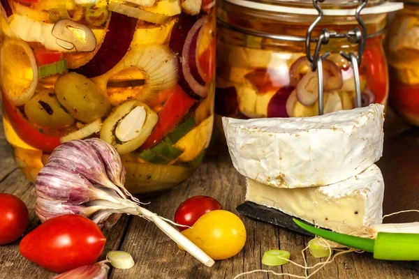 Cheese pickled in olive oil. Home-made pickled cheese. Jar with Camembert cheese marinated in oil on wooden table. — Stock Photo, Image