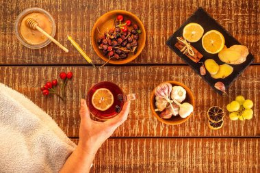 Ahşap arka planda bir fincan bitki çayı. Geleneksel tıp, grip konsepti. Grip ve soğuk algınlığına karşı gül çayı. Grip tedavisinde kullanılıyor. Grip salgını.