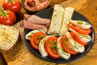 Domatesli, pastırmalı ve jambonlu Mozzarella peyniri. Sağlıklı kahvaltı, güzel manzara. Ev yapımı diyet yemekleri..
