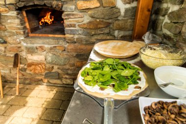 Ev yapımı ıspanaklı pizzayı mantarla hazırlıyorum. Vejetaryen pizzası. Ev yapımı. Sağlıklı yiyecekler. Geleneksel İtalyan yemekleri.
