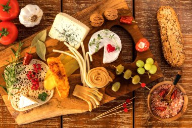 Peynir tahtası - çeşitli peynir kompozisyonu. Tahta tahtada peyniri üzümle karıştır. Sağlıklı yemek hazırlıyorum. Süt ürünleri.