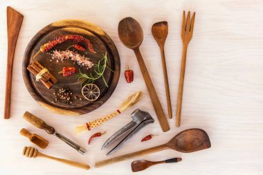 Ahşap arka planda mutfak aletleri. Ahşap masada çeşitli mutfak aletleri var. Aşçı aletleri. Ev yemeği..