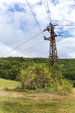 Enerji konsepti. Ekolojik enerji. Kırsal alandaki eski paslı elektrik direkleri ve kabloları.. 