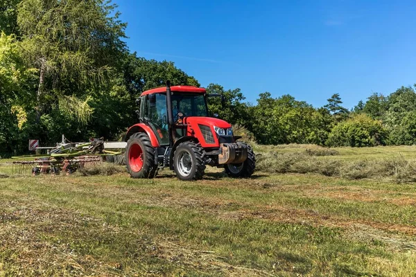 Traktor Merah Bekerja Lapangan Dengan Tedder Dua Rotor Kering Jerami — Stok Foto