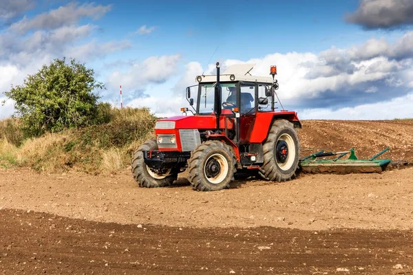 Traktor Merah Membudidayakan Tanah Lapangan Dengan Kultivator Setelah Panen Autumn — Stok Foto