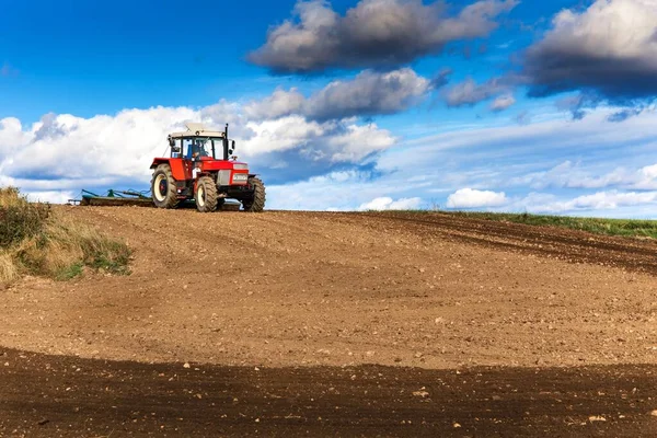Traktor Merah Membudidayakan Tanah Lapangan Dengan Kultivator Setelah Panen Autumn — Stok Foto