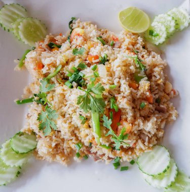 Kızarmış tavuk yumurta pirinç / pilav kızarmış yumurta ve yeşil soğan ile tabakta sebze havuç Çin kal ve salatalığın üzerinde üstten görünüm