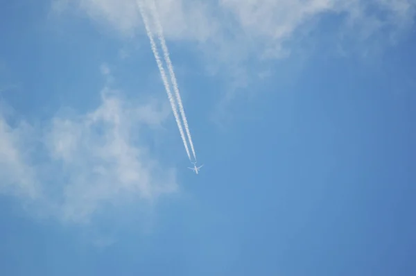 Jet airplane flying the blue sky / trace of the plane in the sky bright day