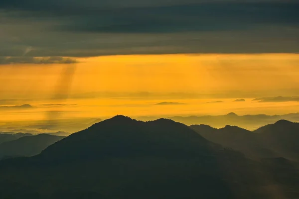 Sun rise in the morning new day / Wonderful landscape sunrise on hill mountain with rays of sunlight shining on the cloud yellow sky - Amazing beautiful mountain range background