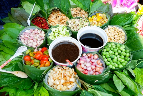 food wrapped in leaves / healthy food with leaf vegetable and herbs various in banana leaf with thai sauce in local food - thai herbs slice for cook food ingredients