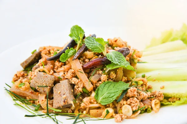 baharatlı kıyılmış domuz salata beyaz tabakta / kıyılmış domuz mash ot ve taze sebze salatalık kuru nane kırmızı biber ve marul-Tay tarzı ile baharatlı yemek