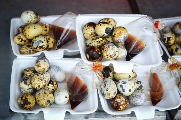 Quail eggs / boiled quail eggs with sauce in box at street food