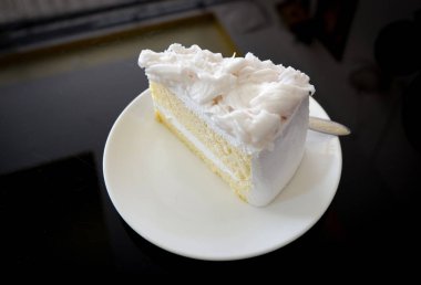 Pasta dilimi / krem vanilya pasta dilim beyaz plaka - Hindistan cevizi kek süt tatlı kahve dükkanı tablo üzerinde