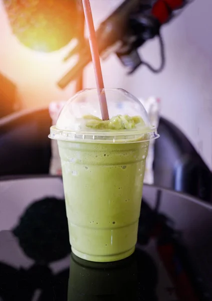 Milk froth green tea smoothie / Iced green tea in plastic cup smoothie matcha green tea latte frappe and straw on table in coffee shop