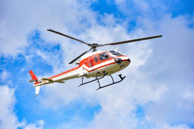 gökyüzünde uçan helikopter / beyaz bulutlar iyi hava parlak gün - helikopter kurtarma ile mavi gökyüzü kırmızı sinek helikopter