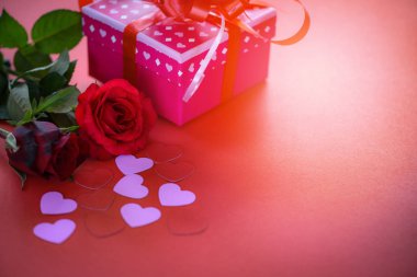 Sevgililer günü hediye çiçek aşk kavramı kutu / pembe şerit yay kırmızı gül çiçek ve kırmızı arka plan kopya alanı üzerinde pembe kalp hediye kutusu