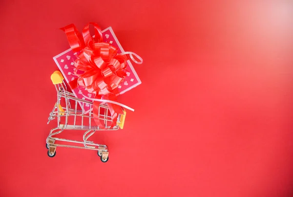 情人节购物和礼品盒 粉红礼品盒与红色丝带蝴蝶结购物车概念快乐圣诞快乐新年或情人节在红色背景 购物假期 — 图库照片