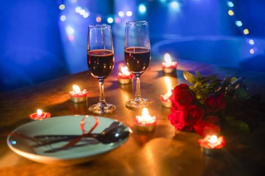 Sevgililer akşam yemeği romantik aşk kavramı / plaka ve çift şampanya cam gül çatal kaşıkla ahşap masa akşam yemeği gece ışık arka plan üzerinde mum ışığında romantik tablo ayarını süslenmiş 