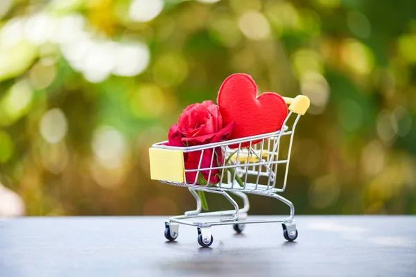 Valentines day shopping and roses flower / Shopping cart full with Red Heart and rose flower for Valentines day on nature background - Shopping vacation