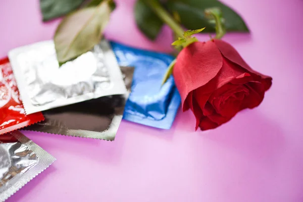 Condom Prevent Pregnancy Contraception Valentines safe sex concept / Birth Control with Condom and roses flower love on pink background -  pregnancy or sexually transmitted disease