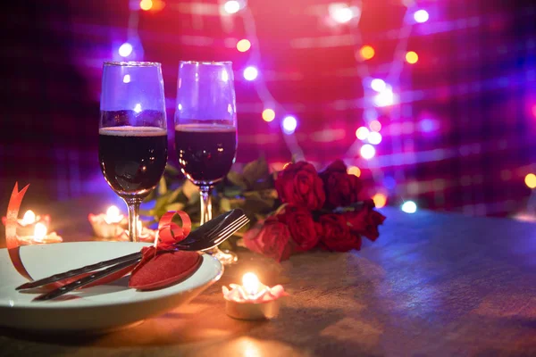 Valentines dinner romantic love concept / Romantic table setting decorated with Red heart fork spoon on plate and couple champagne glass wine roses with candlelight on wooden table dinner at night — Stock Image Valentines Dinner Romantic Love Concept Romantic Table Setting Decorated Red Stock Photo