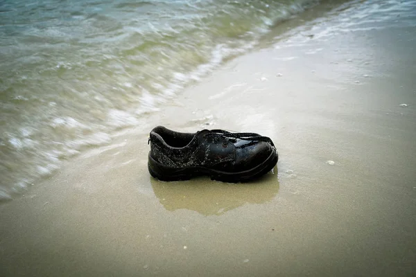 shoes garbage the beach / sea water pollution with old shoes on sand in the beach save the earth concept