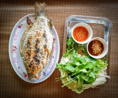 Izgara balık tilapia / aşçı Tilapia plaka Asya tarzı gıda sos ve taze sebze ile tuz ile ızgara - balık Tay tilapia Yakılan ot yakmak