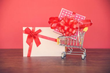 Sevgililer günü alışveriş ve hediye kartı hediye kutusu / pembe mevcut kutu kırmızı şerit yay üzerinde neşeli Noel tatil mutlu yeni alışveriş sepeti ile yıl ya da Sevgililer günü kırmızı arka plan - tatil alışveriş