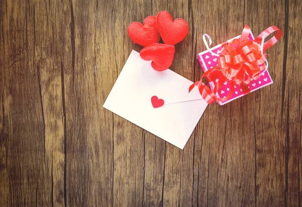 Valentines day gift box pink on wood background / Valentines day card and gift box ribbon bow on wooden - Envelope love mail Valentine Letter Card with Red Heart Love concept